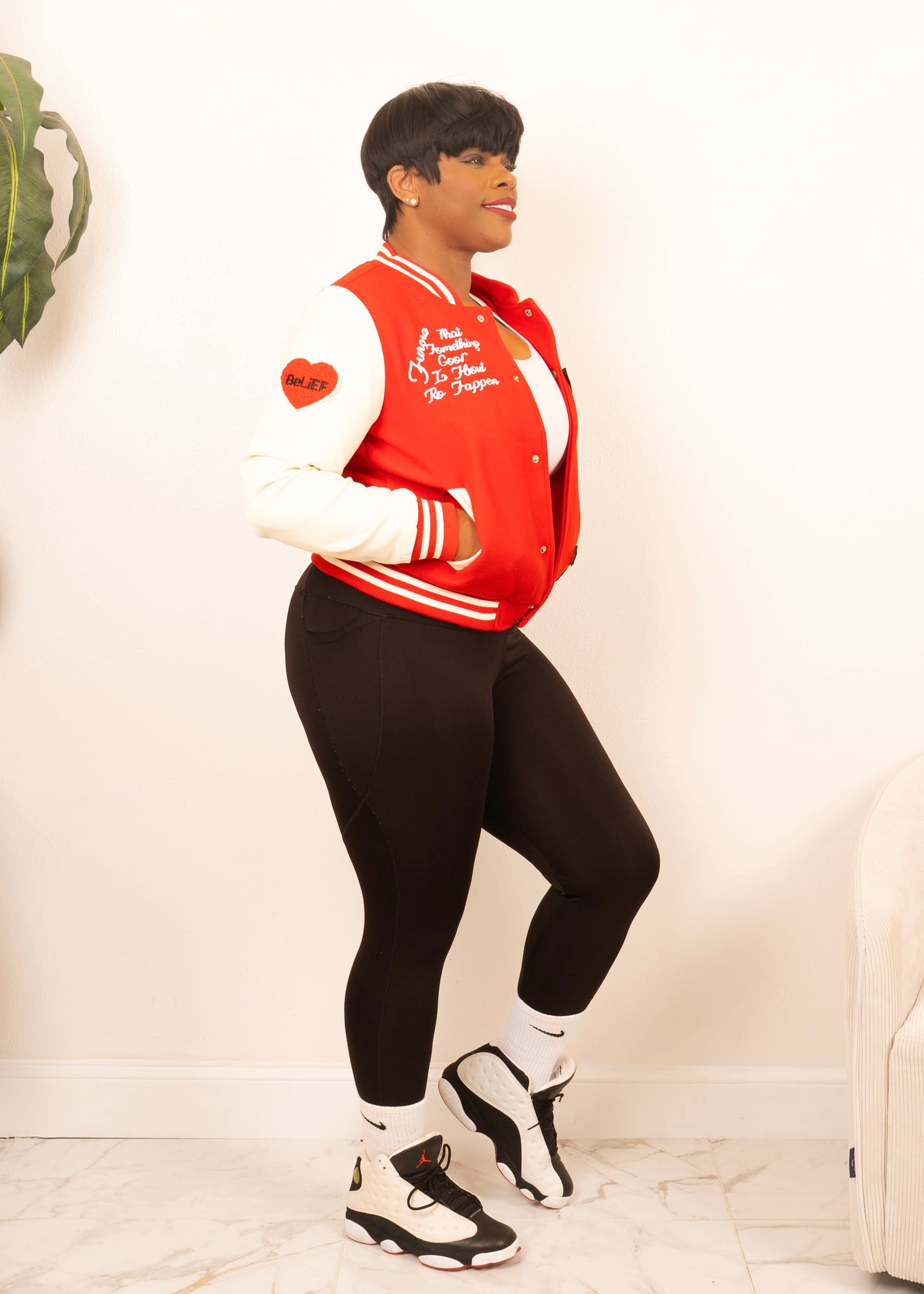 Women’s red and cream varsity bomber jacket styled as casual streetwear, classic letterman design with cropped fit
