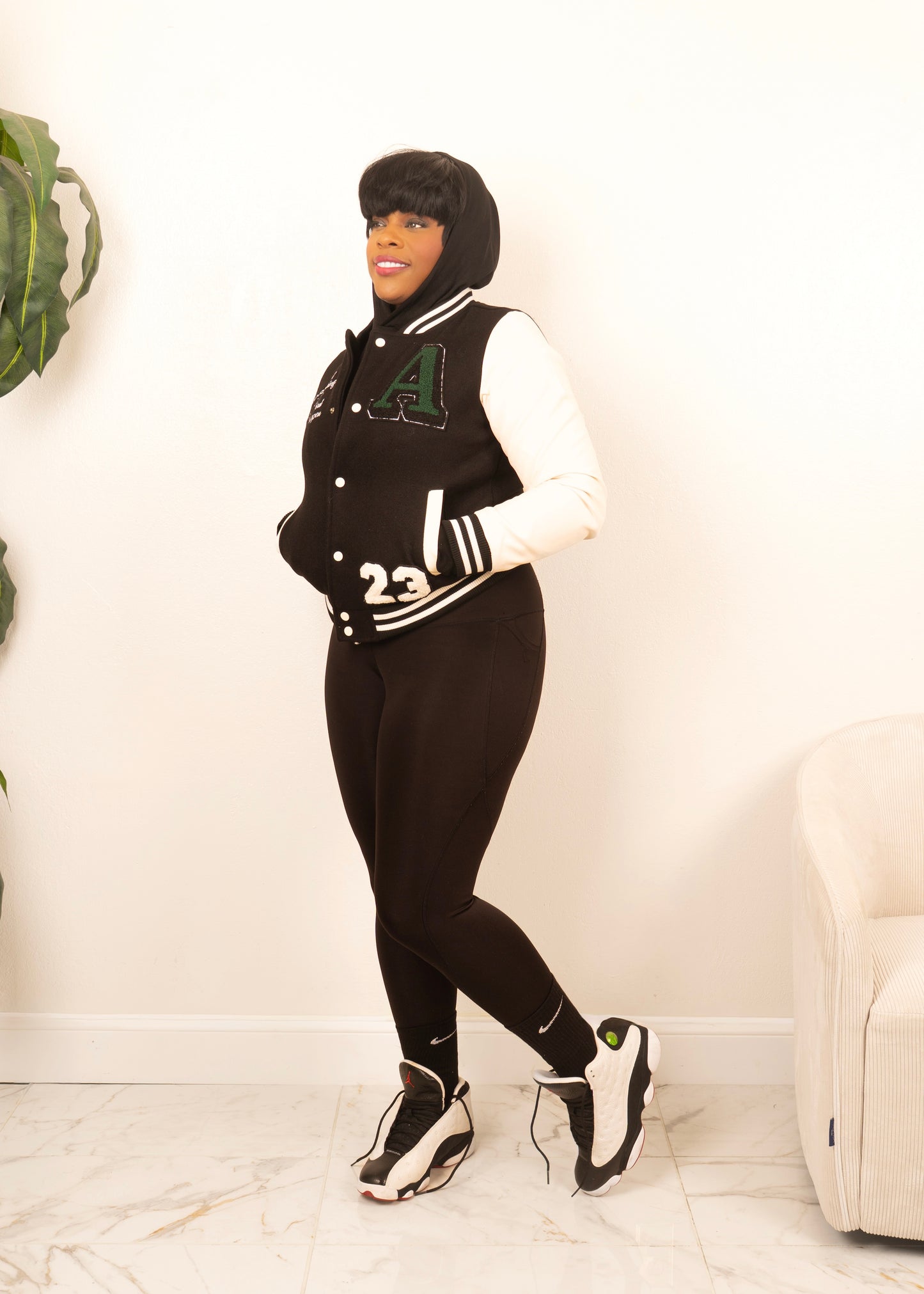 women’s varsity jacket styled with leggings and sneakers blending sporty comfort and modern street style