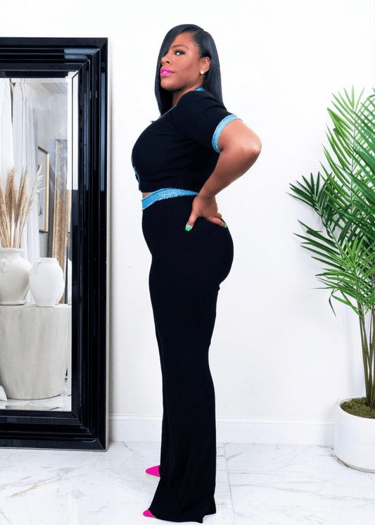 Side view of a woman wearing black wide-leg stretch pants and short sleeve V-neck top with blue trim – stylish two-piece  set from Opulent Gurlz California boutique