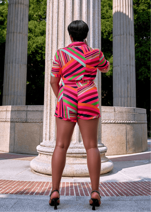 Back view of model wearing a vibrant multicolor summer outfit with tie-waist shorts and a curve-hugging fit—perfect for bold, confident vacation looks.

