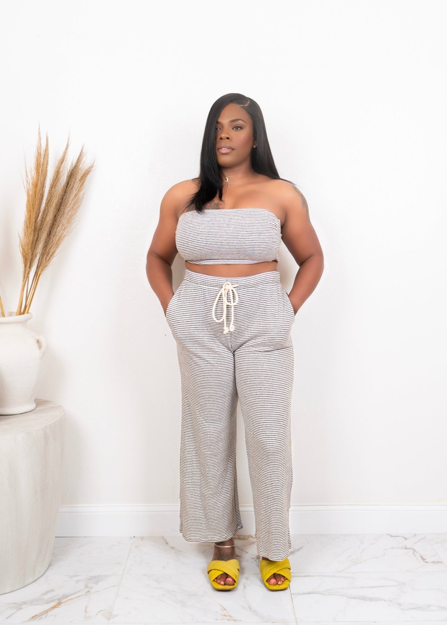 Black woman wearing neutral tube top and drawstring lounge pants with yellow slides – two-piece casual summer set from Opulent Gurlz boutique
