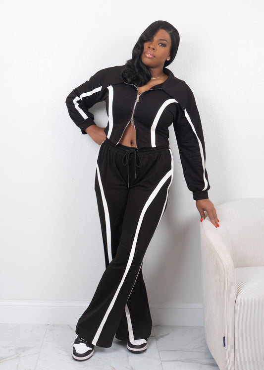 Black two-piece tracksuit with white contrast piping, cropped zip-up jacket and high-waisted wide-leg pants styled with sneakers