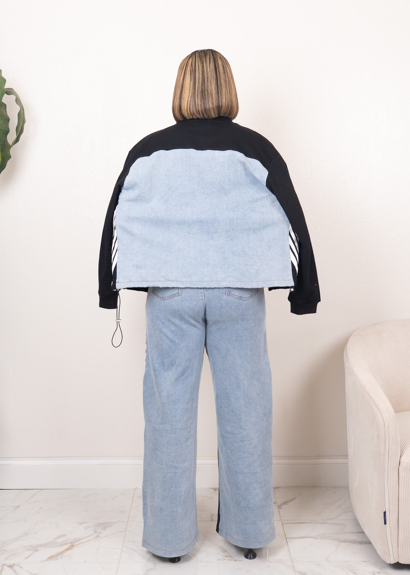 Back view of black contrast track set with cropped zip-up jacket and wide-leg denim panel pants showing relaxed fit and full coverage

