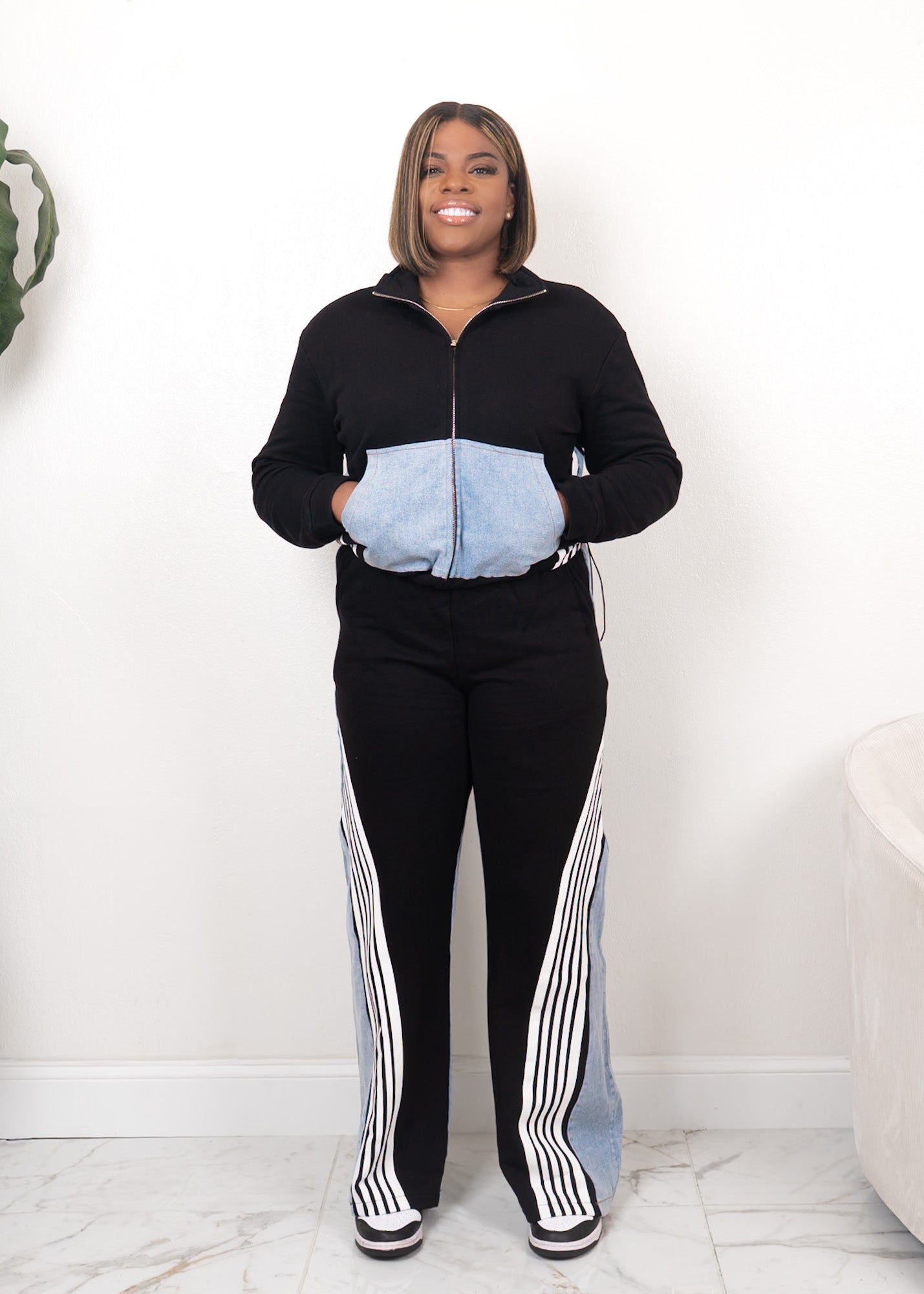 Black contrast track set with zip-up jacket, denim front pocket panel, and high-waisted wide-leg pants with white stripe detailing