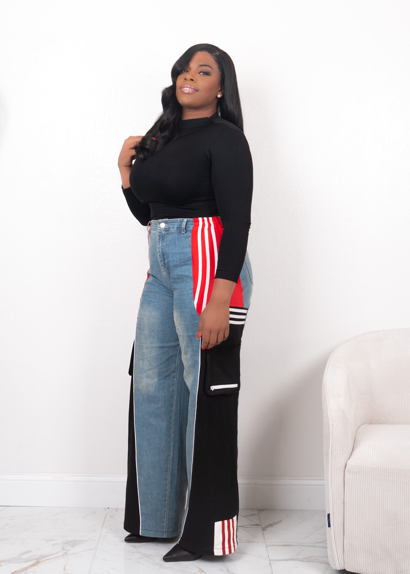 Side view of wide-leg denim contrast track pants with red stripe detailing, black panels, and high-waisted streetwear fit
