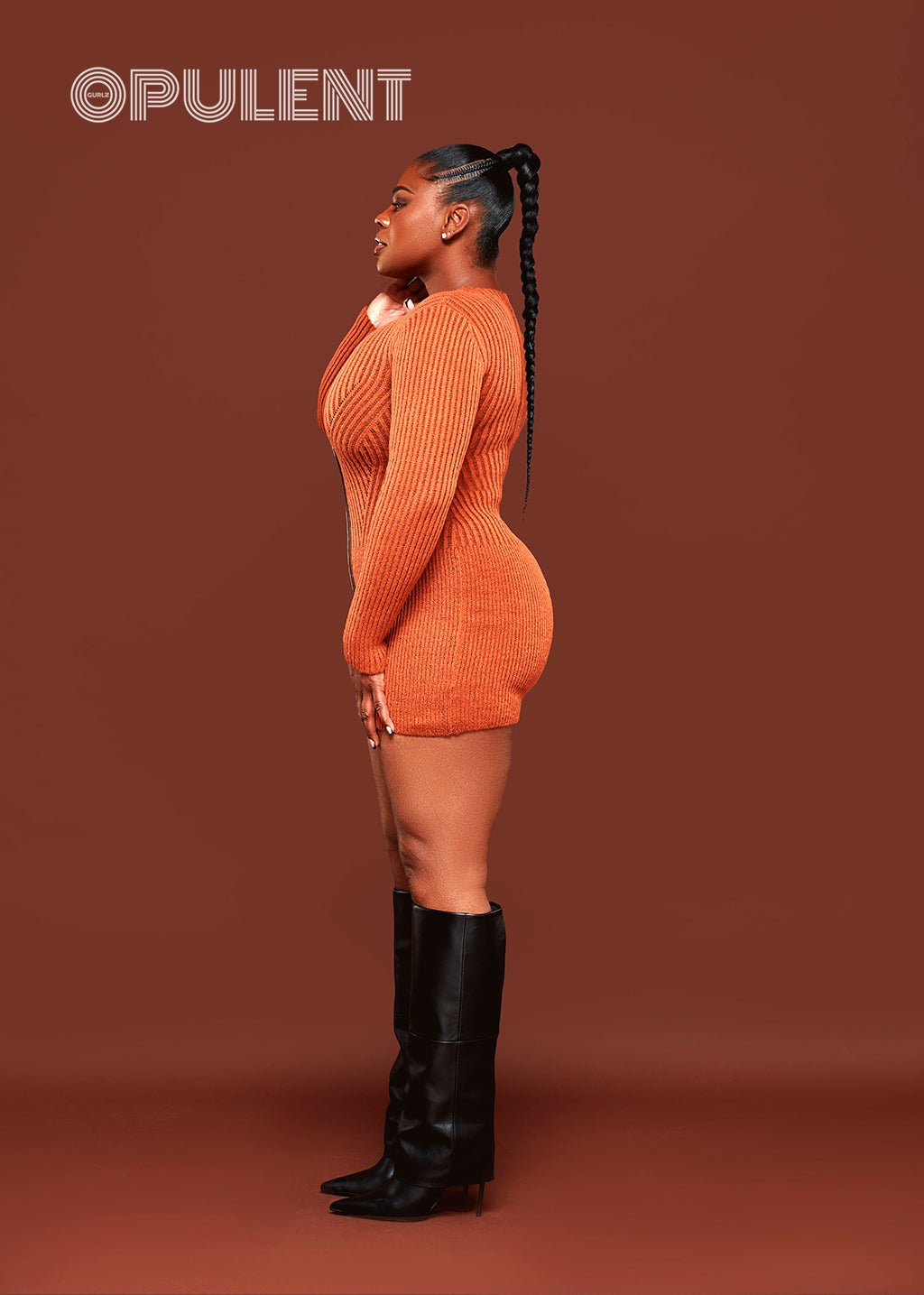 Side view of long sleeve orange zipper sweater dress styled for fall with knee-high boots
