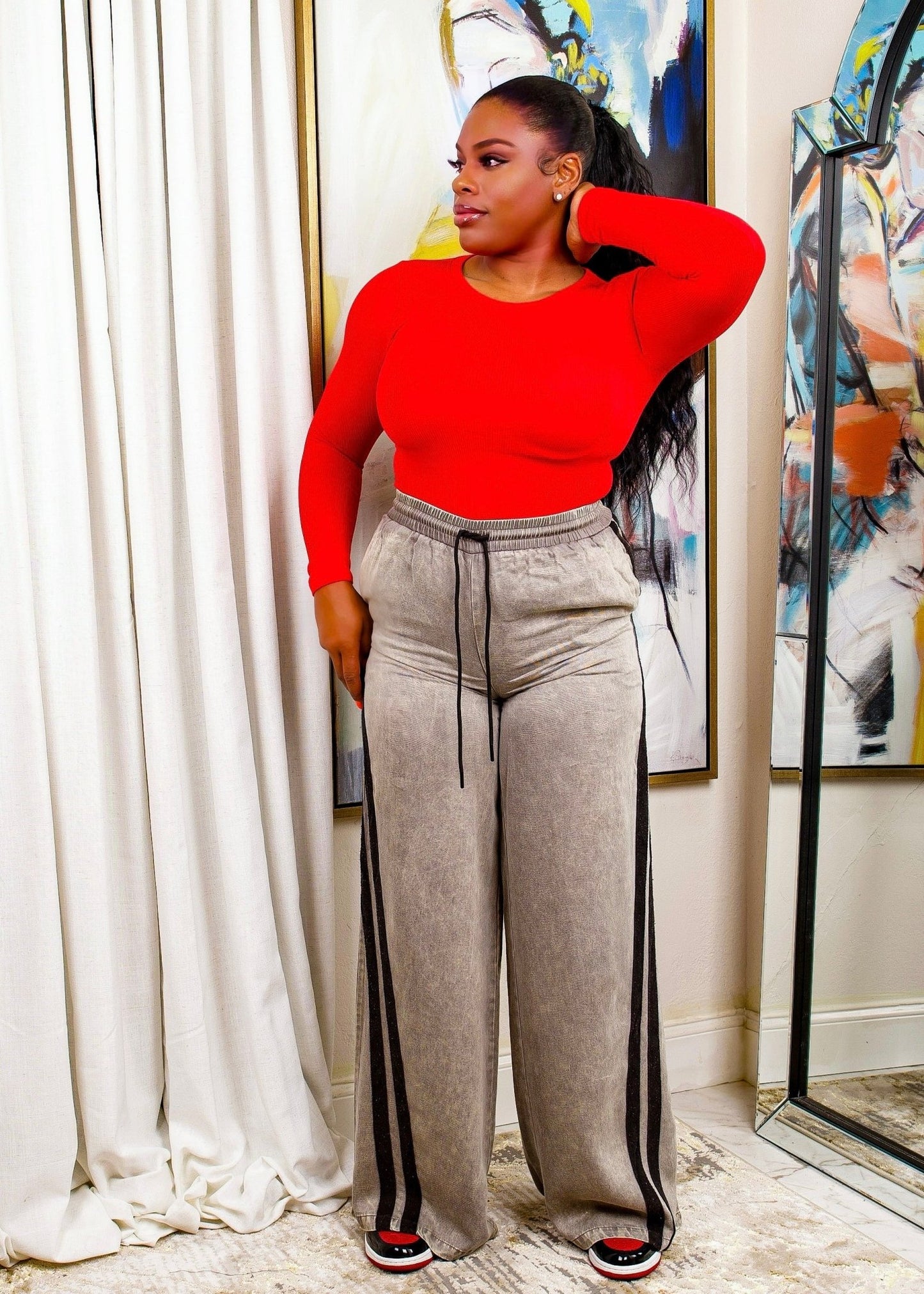 Woman wearing black relaxed straight-leg pants with stripe detail and red top – Miss Relaxed Pants from Opulent Gurlz