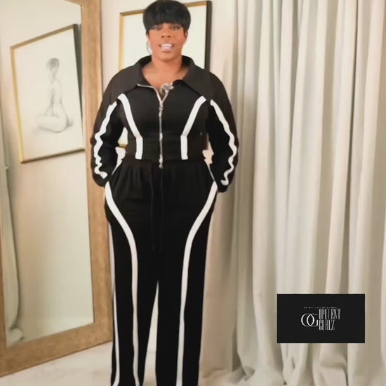 Video explaining the fit of a black contrast track suit with zip-up jacket and wide-leg pants, highlighting comfort and flattering silhouette.