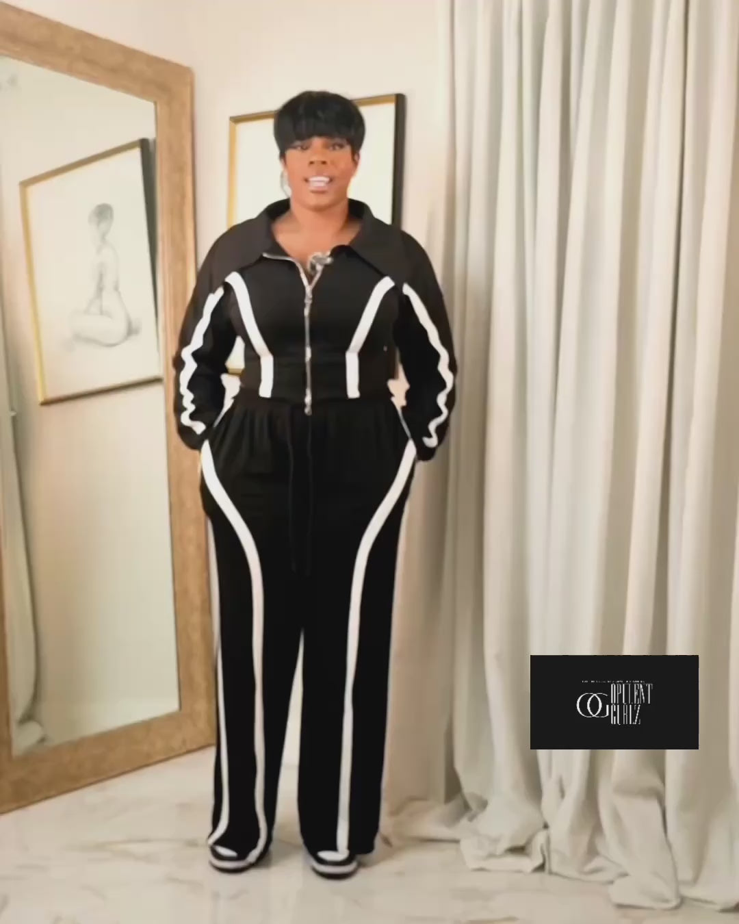 Video explaining the fit of a black contrast track suit with zip-up jacket and wide-leg pants, highlighting comfort and flattering silhouette.