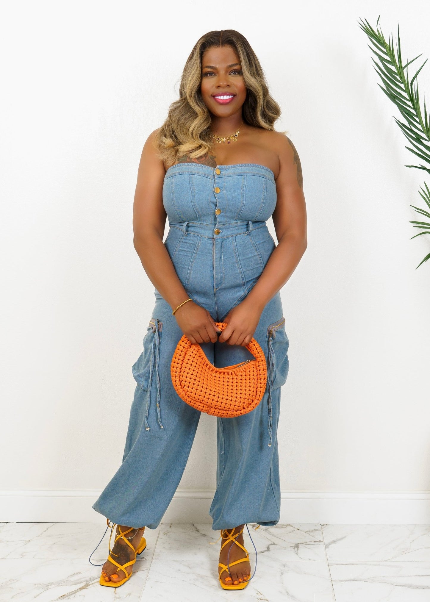 Woman wearing strapless button-up denim jumpsuit with belted waist and wide-leg fit – Snatched in Denim by Opulent Gurlz