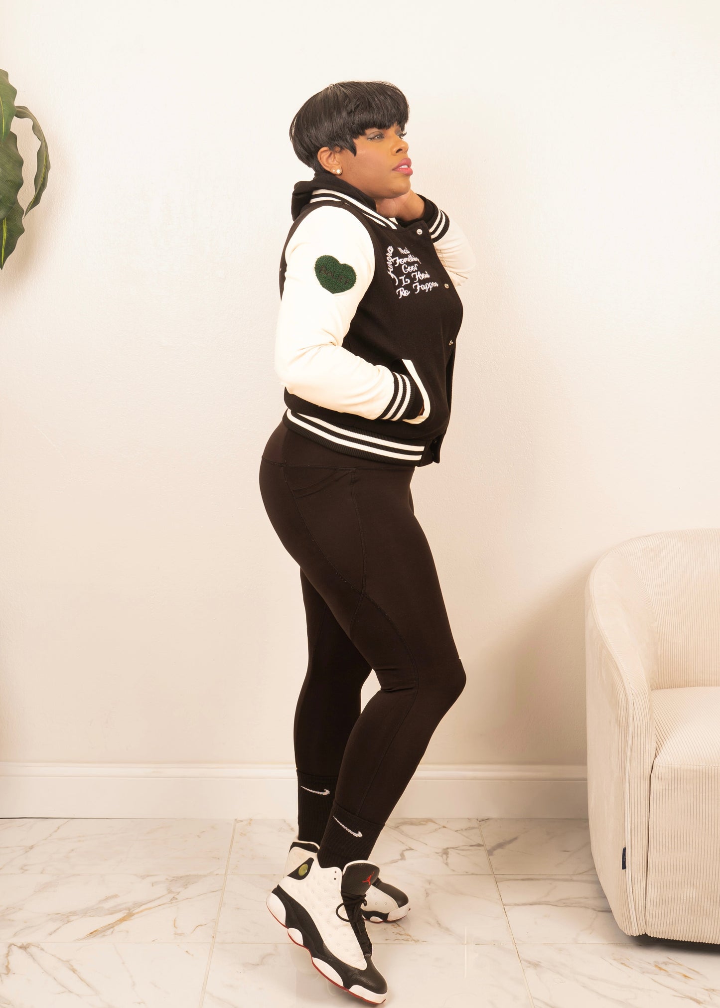 women’s varsity jacket styled with leggings and sneakers for sporty athleisure streetwear look