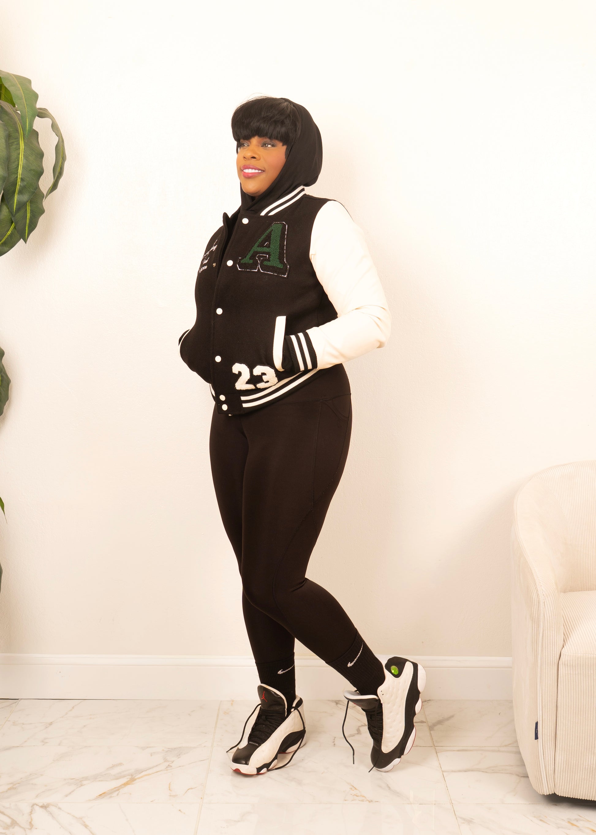 women’s varsity jacket styled with leggings and sneakers blending sporty comfort and modern street style