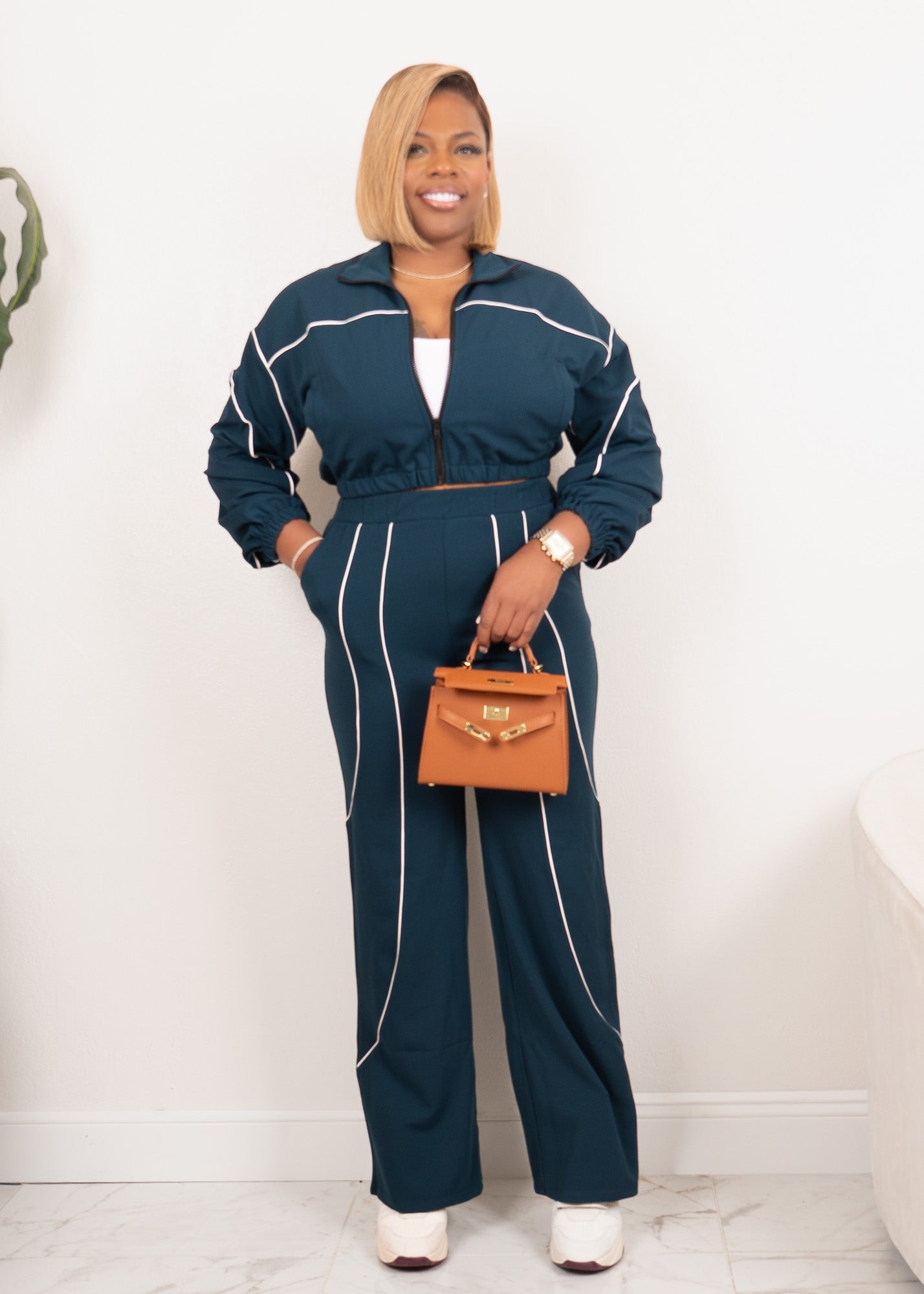 Women’s hunter green contrast piping track set, full body front view with cropped zip jacket and wide leg pants, white background.