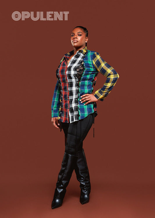 Woman wearing a colorful plaid button-up shirt with drawstring side detail, styled with black leggings and heels